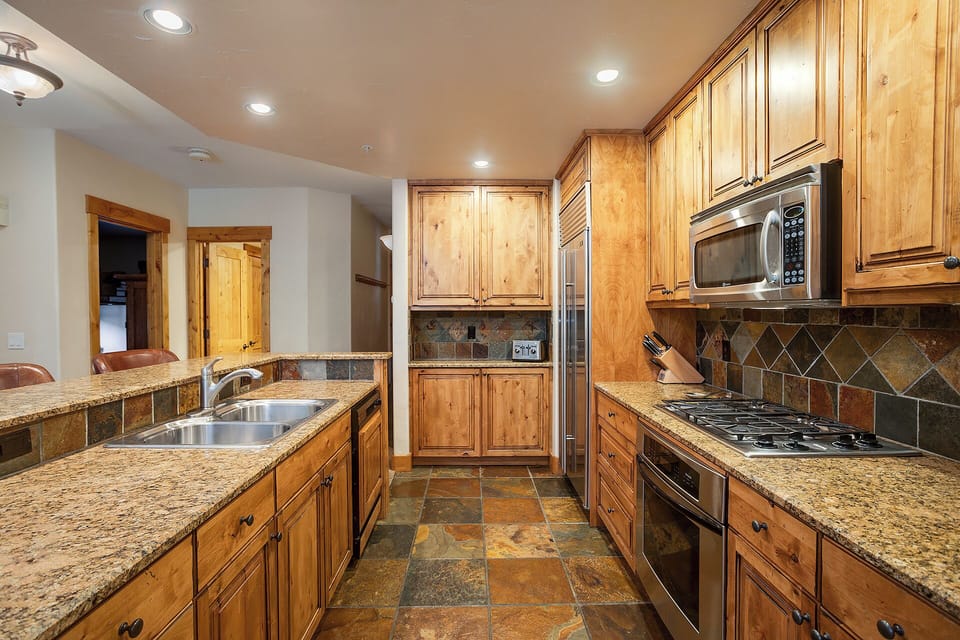 Your gourmet kitchen awaits with granite counters, stainless appliances, and warm wood cabinets—perfect for creating memorable meals during your stay.