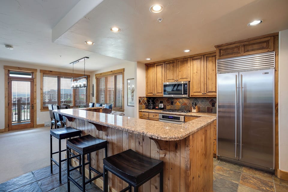 Your gourmet kitchen welcomes with granite counters, stainless appliances, and a breakfast bar perfect for morning coffee or evening wine.