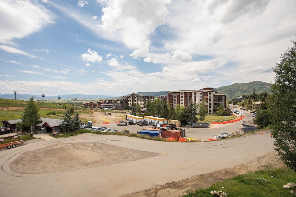 Mountain resort village with gondola lifts, multi-story lodges, and expansive natural landscape creating an alpine getaway atmosphere.