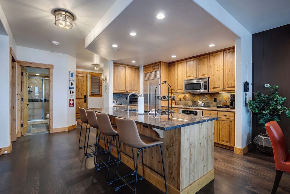 Your spacious kitchen features warm wood cabinetry, granite countertops, and a breakfast bar where you can gather for morning coffee.