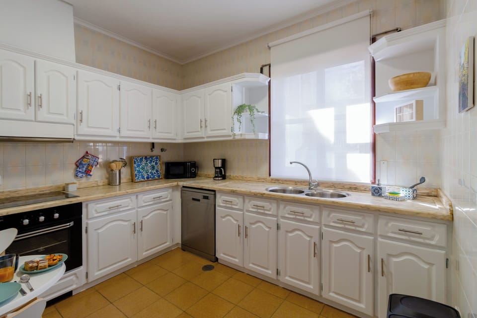 Partial view of kitchen with sink, microwave oven, and coffeemaker.