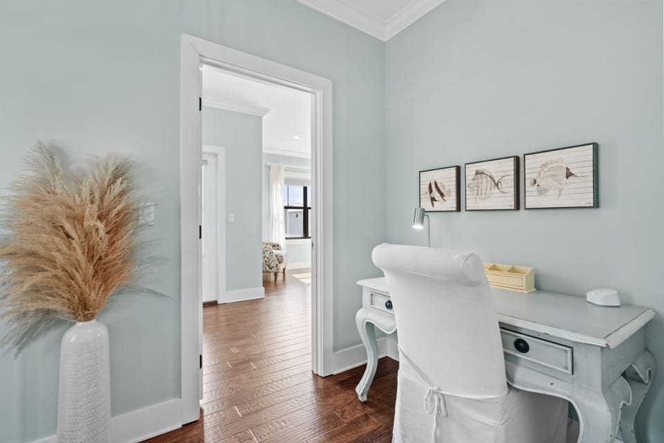Charming hallway workstation with a vintage-style desk and coastal decor—perfect for catching up on emails or journaling between beach outings.