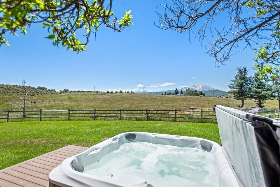 Hot tub and fenced yard with a view