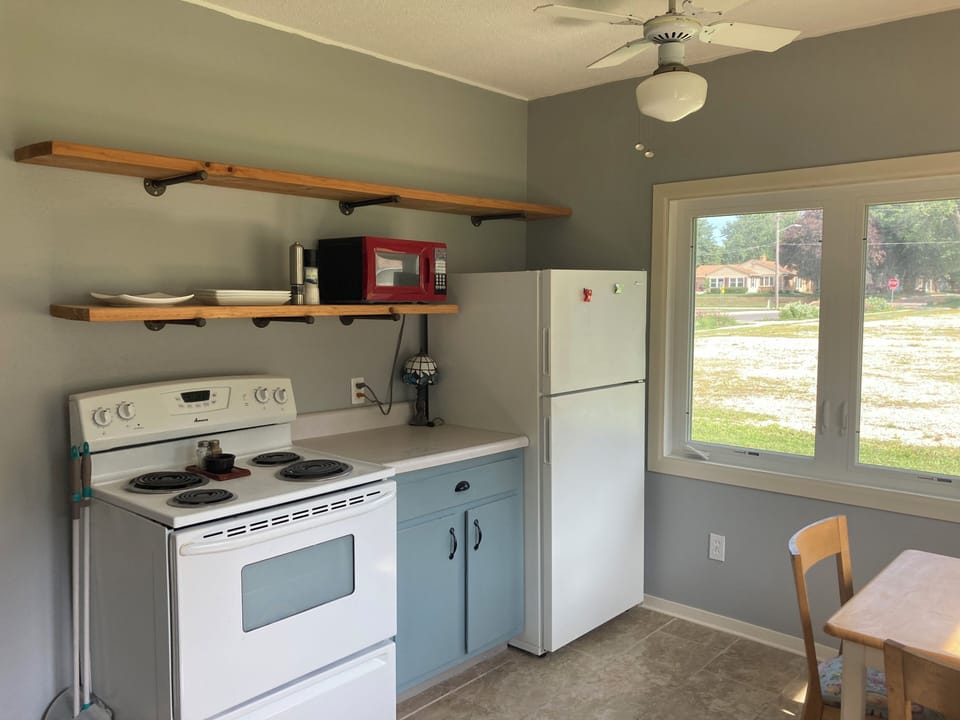 Kitchen with stove, microwave, fridge, cooking tools.