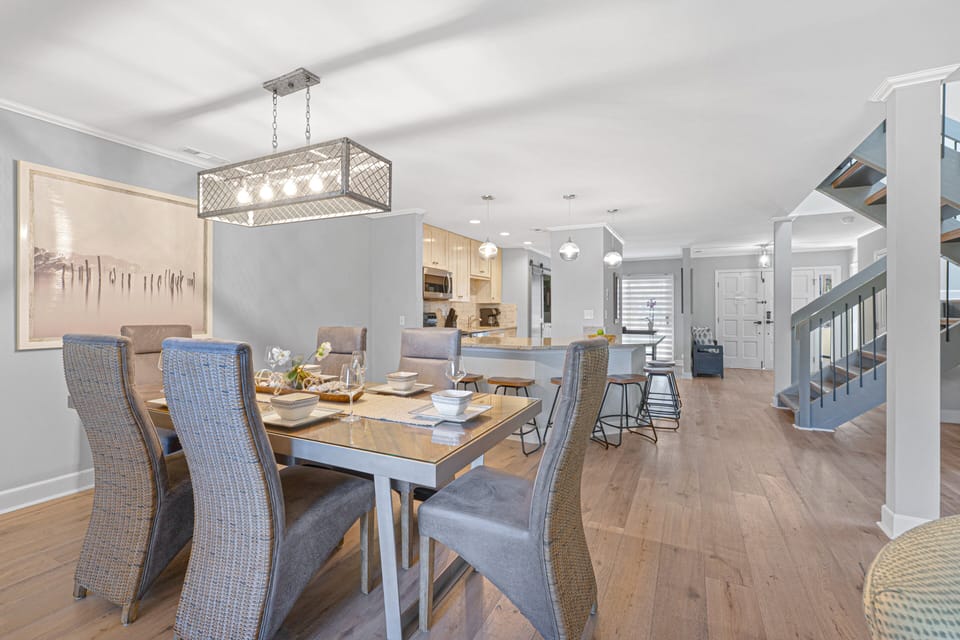 This bright, open living space seamlessly connects the living room, dining area, and kitchen—ideal for gathering and entertaining.