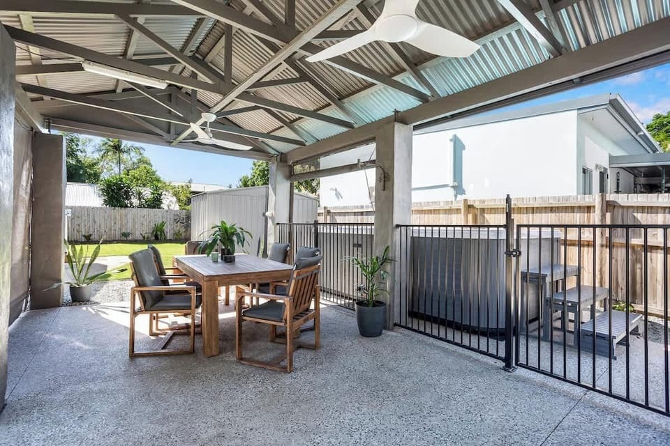 Enjoy outdoor living under the covered patio, where a dining setting and a BBQ invite alfresco meals in the tropical breeze.