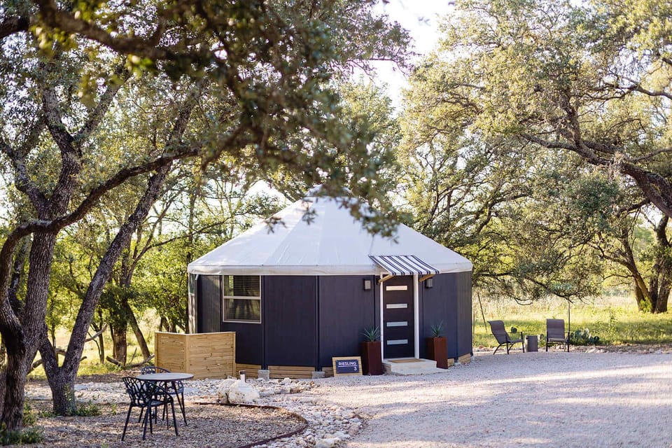 Private modern yurt surrounded by Hill Country oak trees.