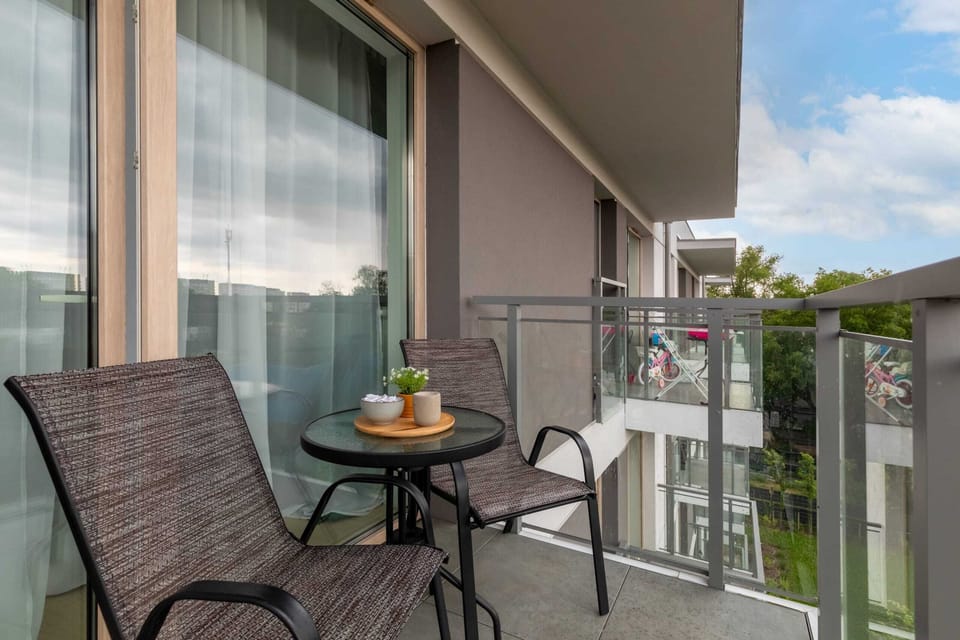 Balcony with a seating area and a small table, offering a relaxing outdoor space with a pleasant view.

