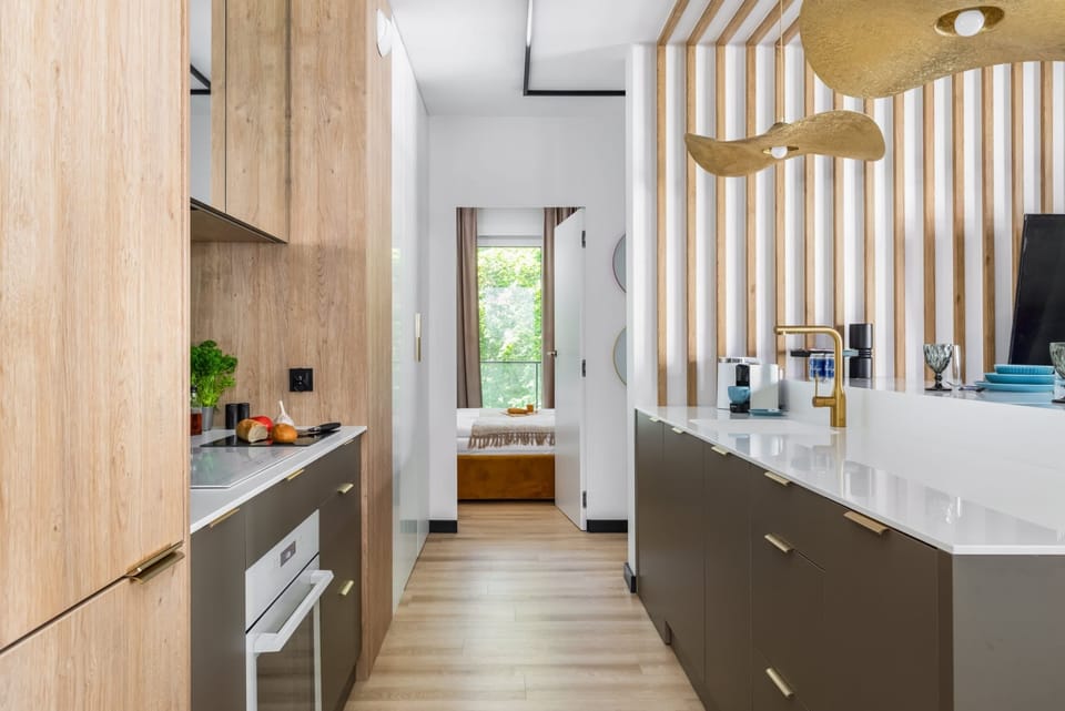 Modern kitchen with wood and white finishes, sleek design, and natural lighting.

