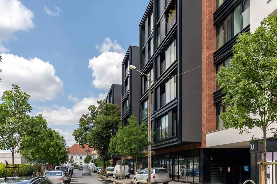 Street-level view of the building with contemporary architecture and a clean urban setting.

