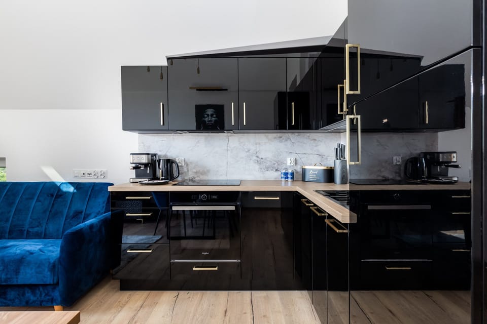 Modern kitchen with sleek black cabinets, built-in appliances, and a contemporary design.

