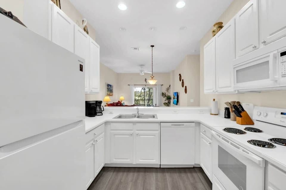 Modern kitchen with white cabinetry and open view to the living area