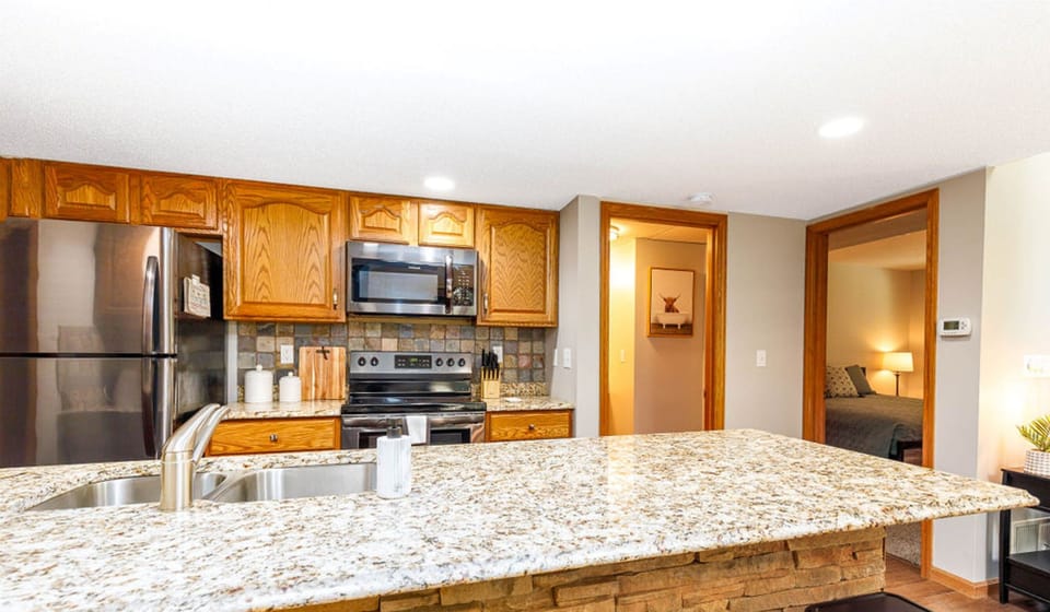 Fully stocked kitchen with 4 stools at breakfast bar