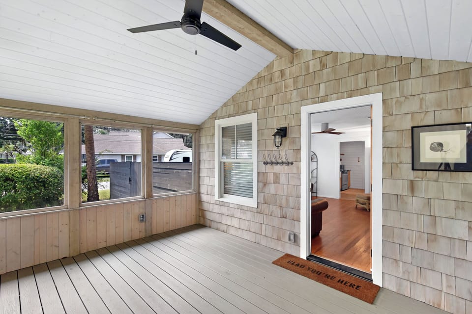 Screened Front Porch Entry - Screened front porch with ceiling fan, tabby wall, entry door, and connection to the living room.