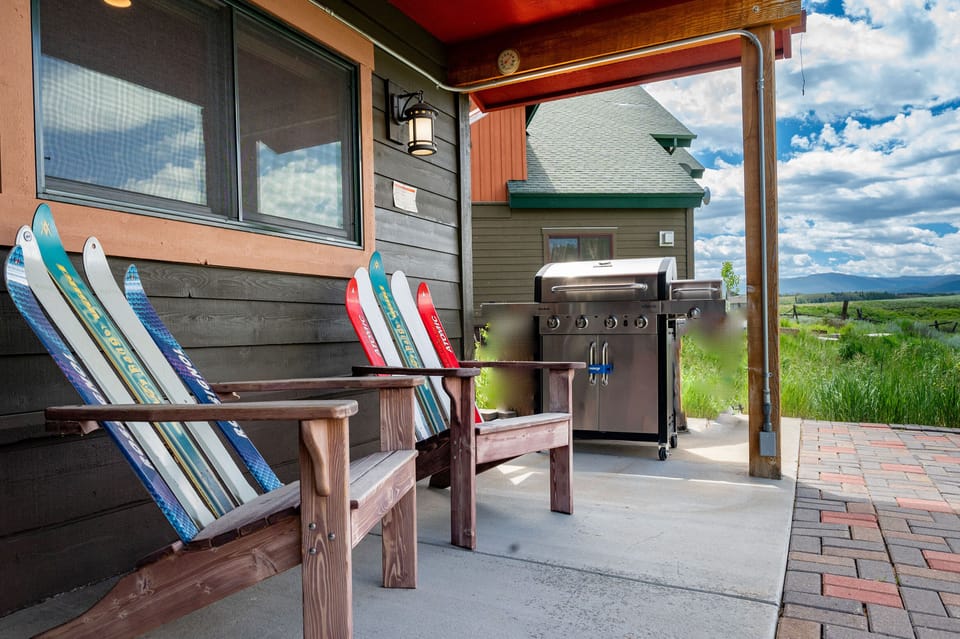 Your private patio offers colorful seating and a premium gas grill, perfect for outdoor dining with mountain views.