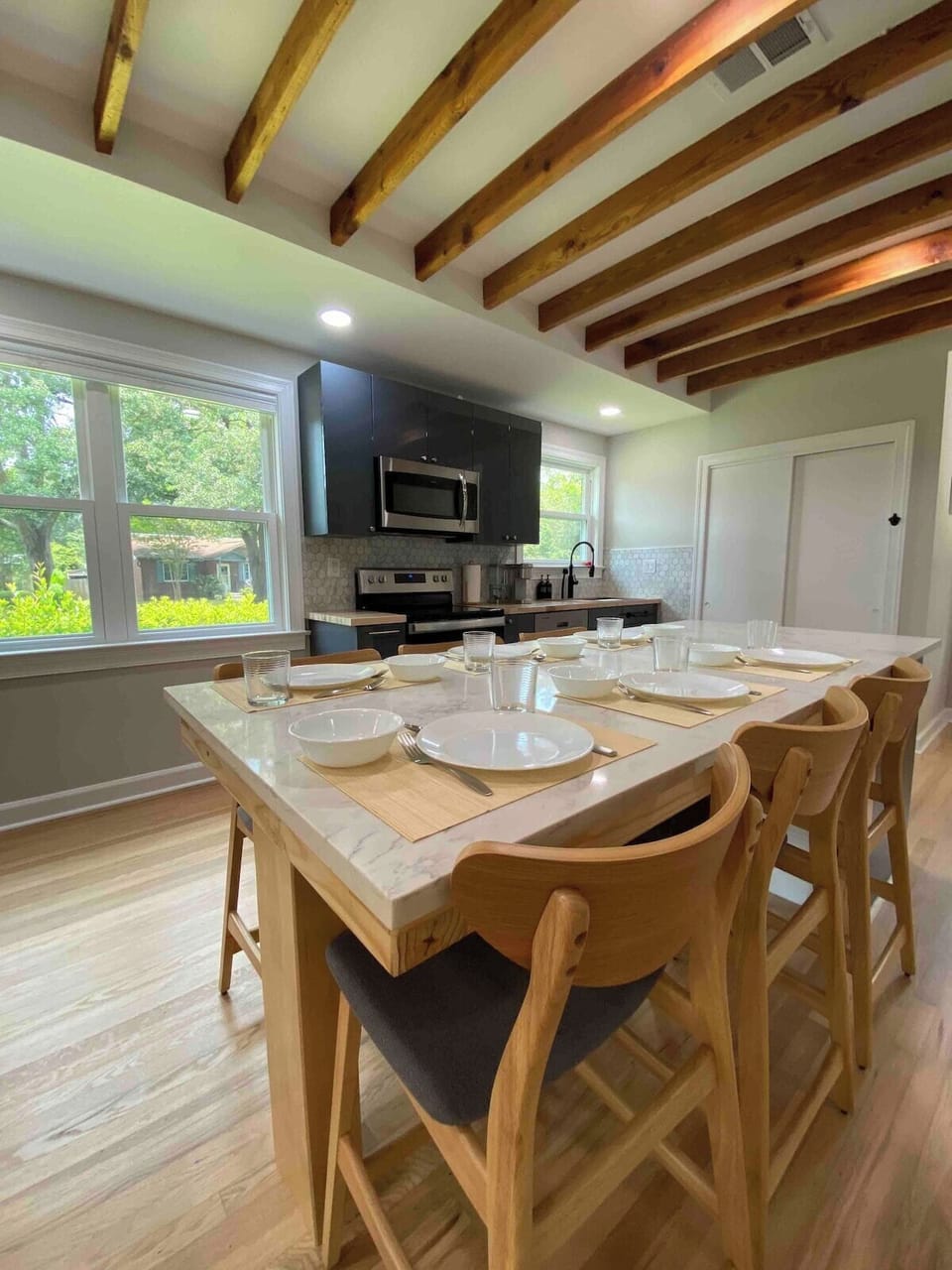 Immerse yourself in the heart of the bright kitchen, a culinary oasis that beckons six people to gather around and partake in a family feast, creating lasting memories of laughter, delicious aromas, and shared moments of joy.