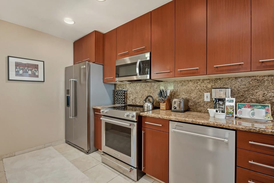 A modern kitchen with stainless steel appliances and granite countertops, perfect for prepping your vacation meals.