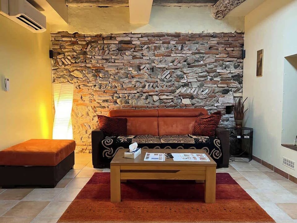 Canapé en cuir et mur en brique rouge dans le salon voûté