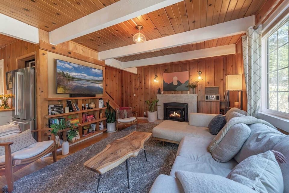 Living room with Smart TV, fireplace, cozy sectional couch, record player and sound bar. 