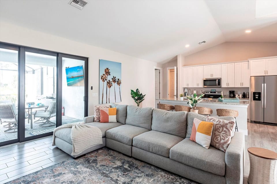 Living Room Oasis: Bright, airy space with comfy seating and a view of tropical paradise!
