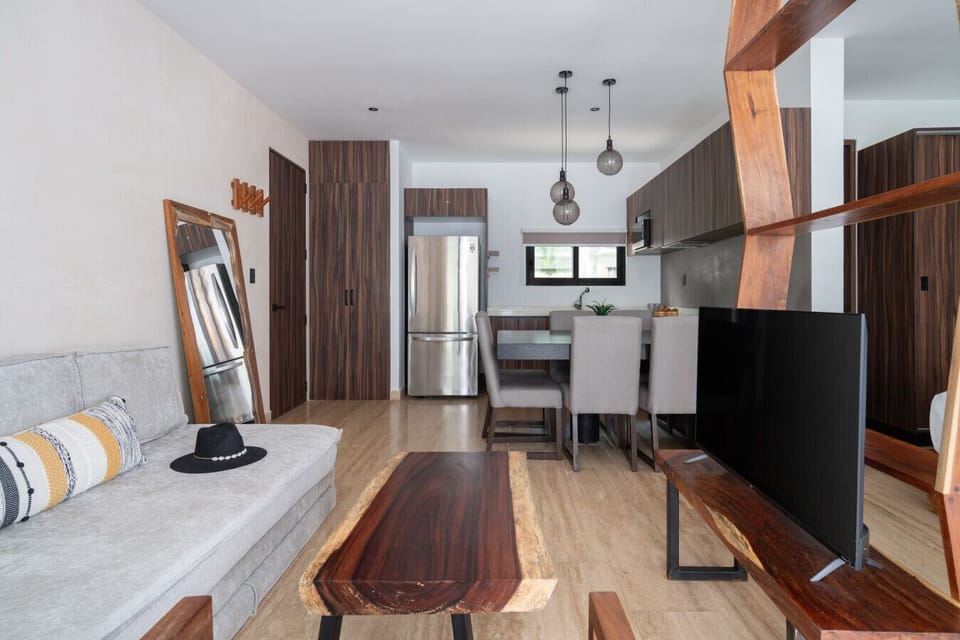 Living area with sofa, TV, coffee table, and direct access to private patio.