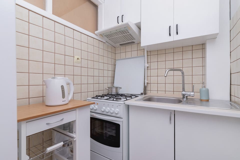 Fully equipped kitchen with a stove, microwave, and kettle, perfect for home cooking.

