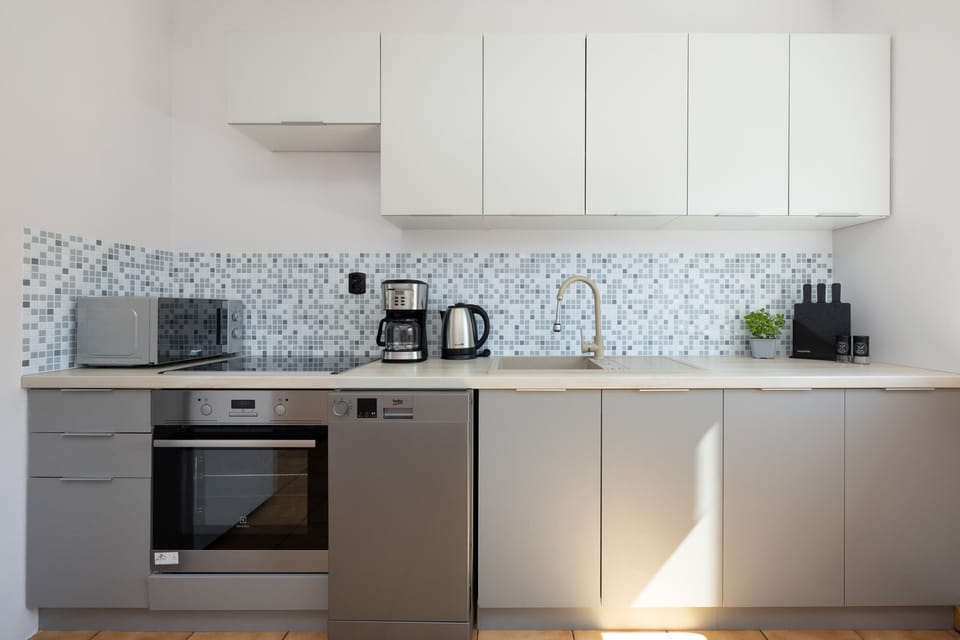 Modern kitchen with white cabinets, stainless steel appliances, and a clean layout.

