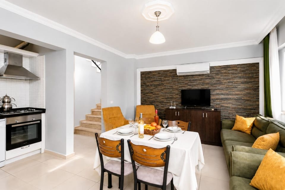 Living room with sofa, dining area, kitchen, A/C, WiFi internet, and satellite TV