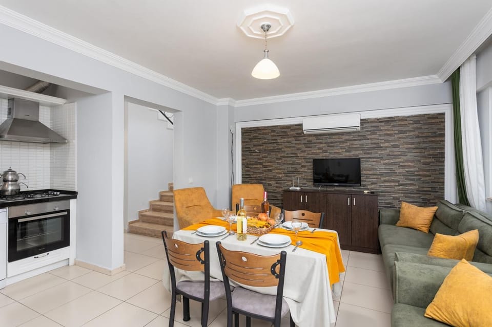 Living room with sofa, dining area, kitchen, A/C, WiFi internet, and satellite TV