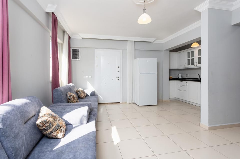 Open-plan living room with sofas, kitchen, A/C, WiFi internet, and satellite TV