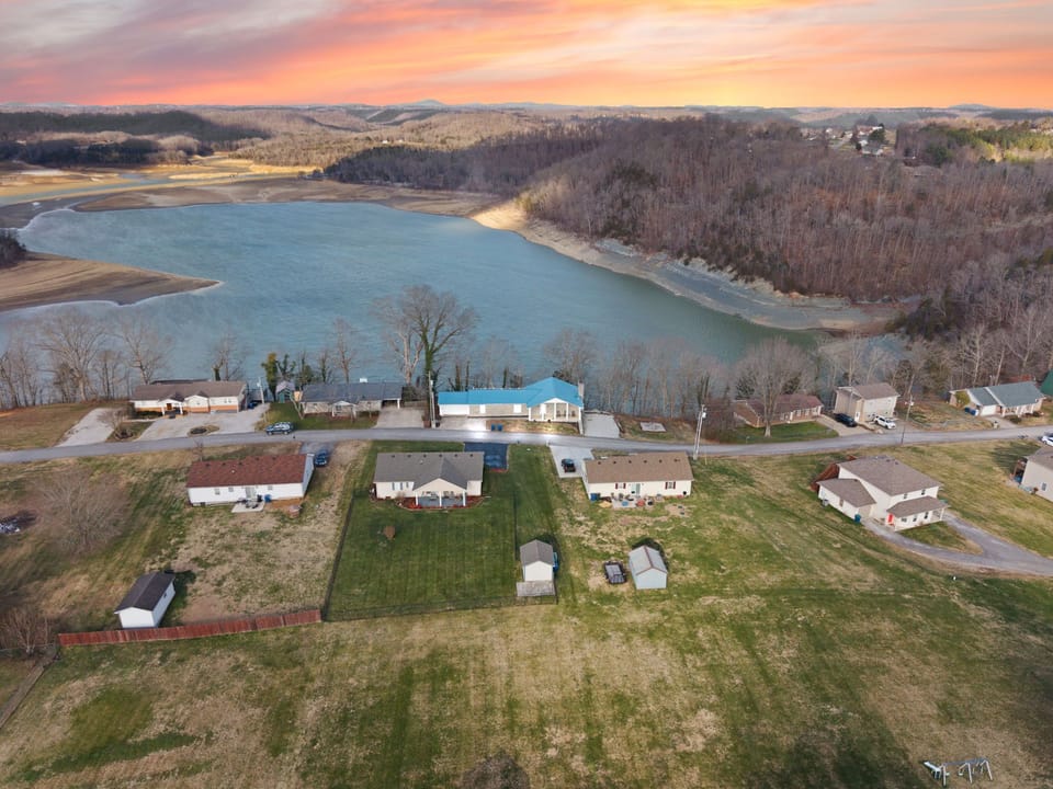 Lakeside retreat with wide lawns, quiet cove, and glowing sunset views.