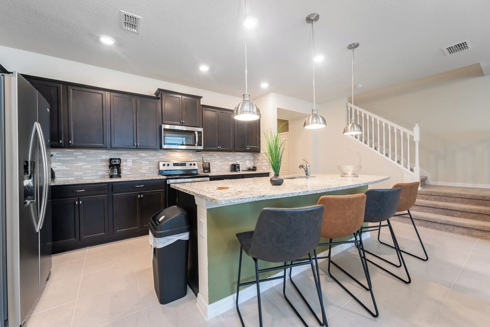 Kitchen showing bar seating area and stairs to upper floor