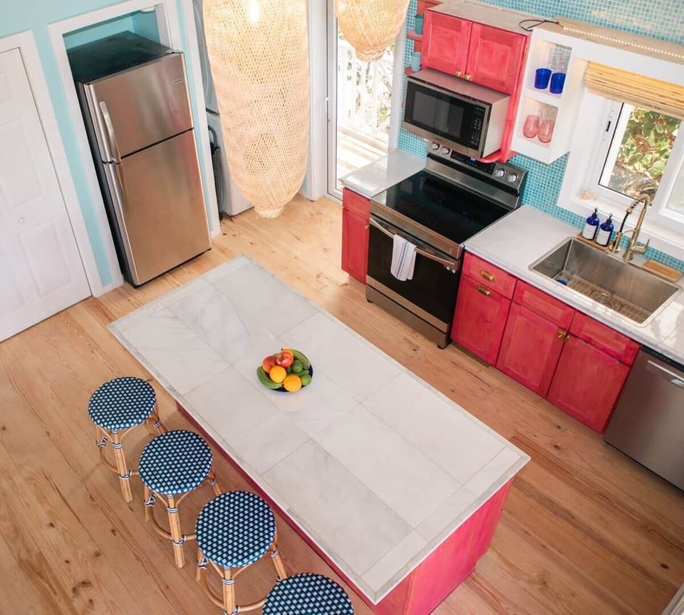 Thoughtfully lit, and embellished with marble countertops and brass pulls, the kitchen beautiful whether facing the beach or the sea grapes!