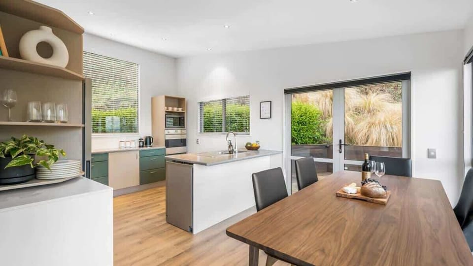 Modern Kitchen with Patio Access
Prepare meals in the fully equipped kitchen, featuring modern appliances and a seamless flow to the patio, complete with a BBQ and stunning lake and mountain views.