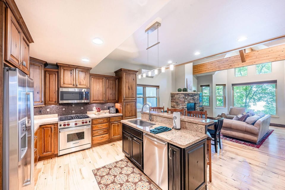 Fully equipped kitchen with stainless appliances and breakfast bar seating.