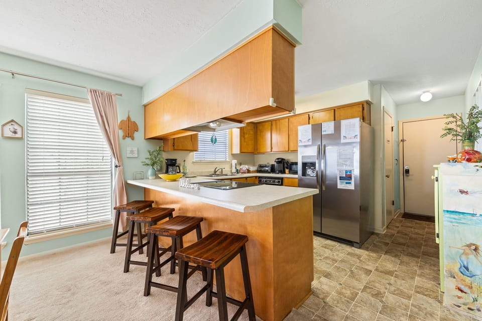 Modern kitchen with a breakfast bar and stainless steel appliances.