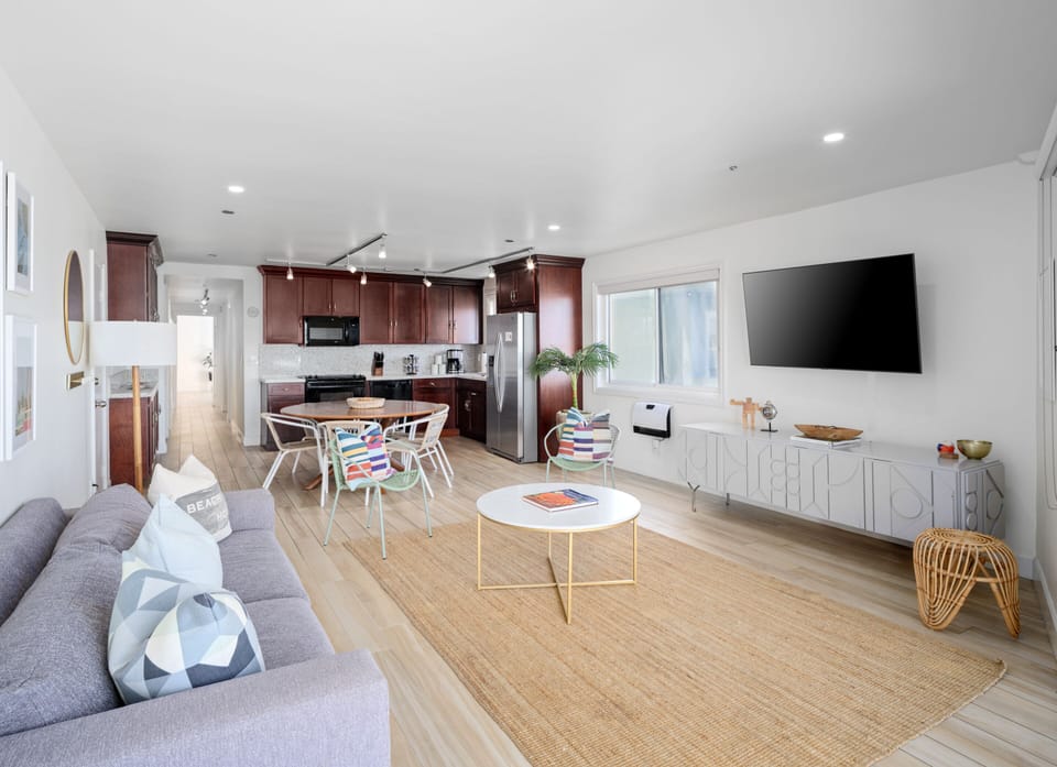 Living room w/ bay views and smart TV. Dining table for 6 and full kitchen.