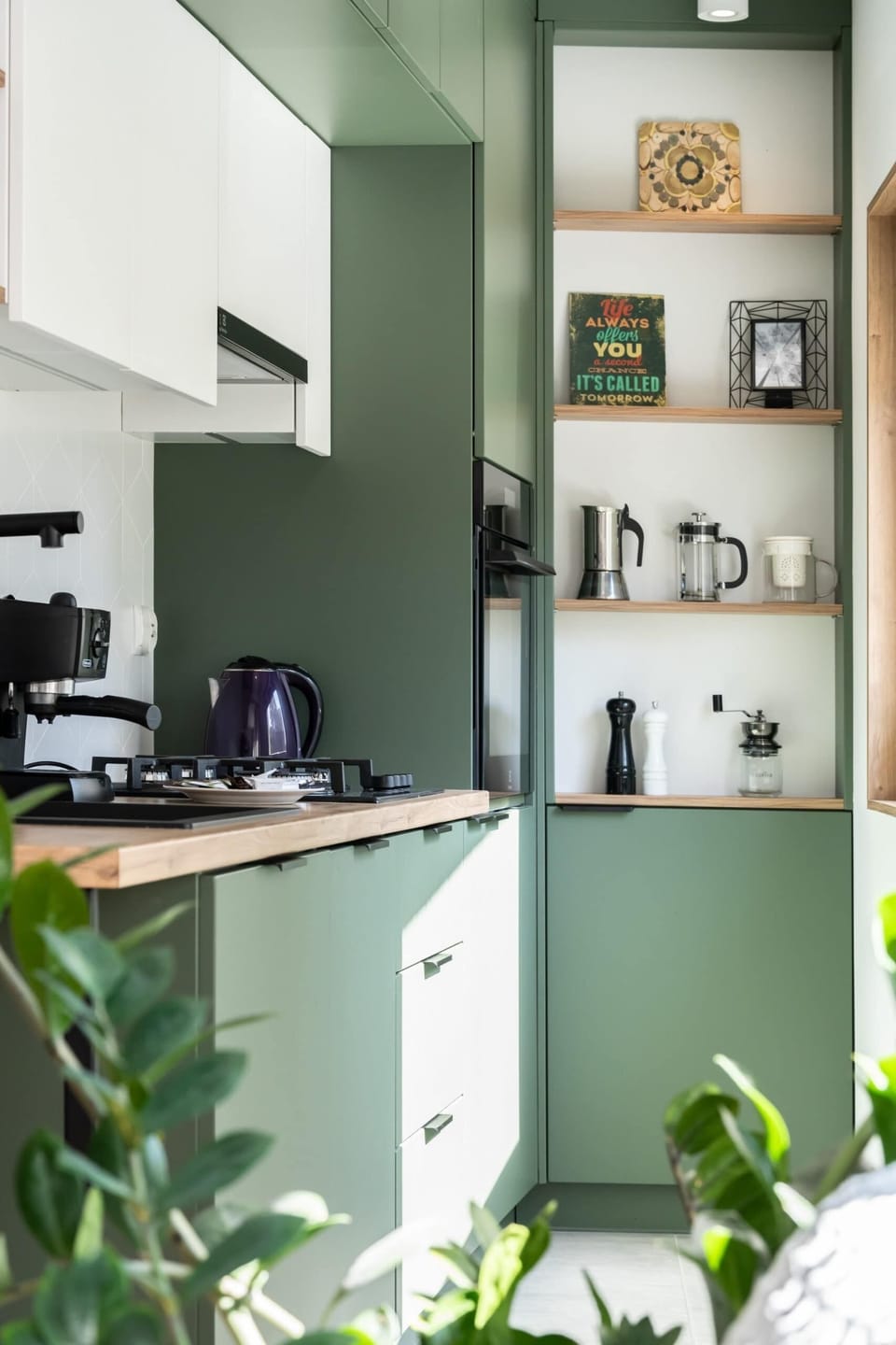 Kitchen corner with efficient storage solutions and sleek green accents.

