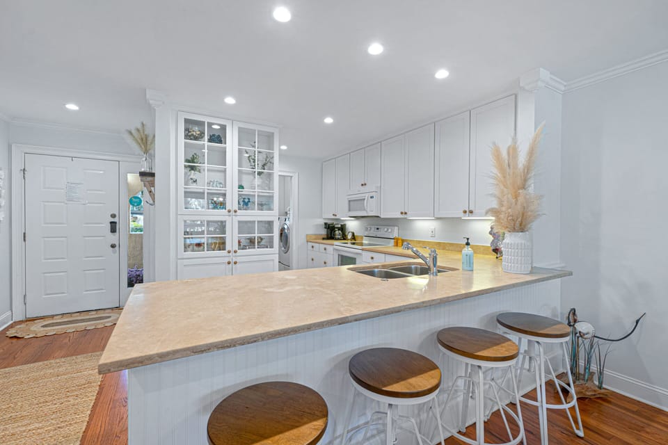 Spacious, well-equipped kitchen with generous counter space and bar seating—ideal for casual meals, morning coffee, and gathering while meals are prepared.