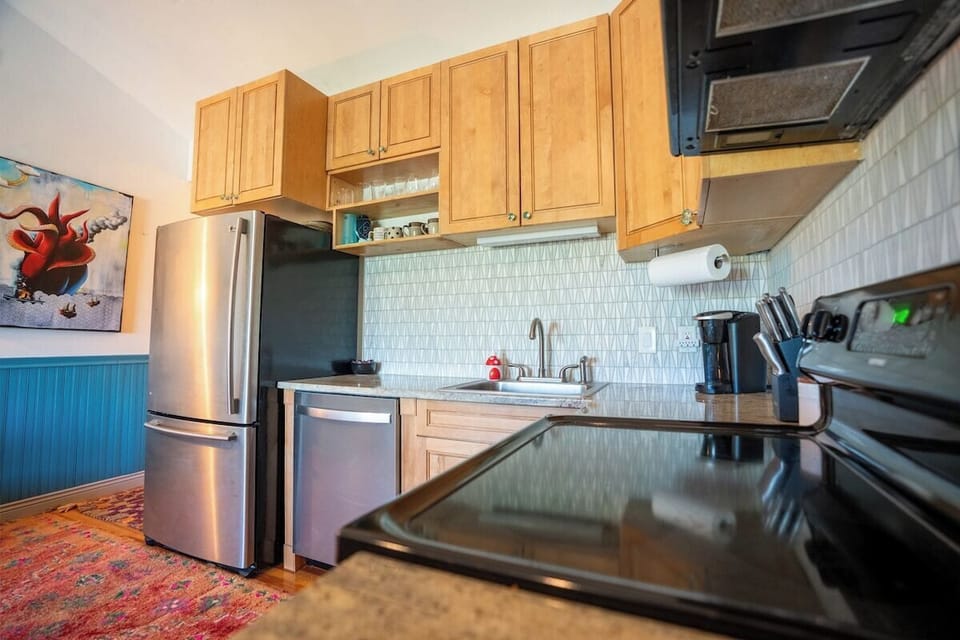 Full kitchen with lots of small appliances like a nice blender and coffee maker.