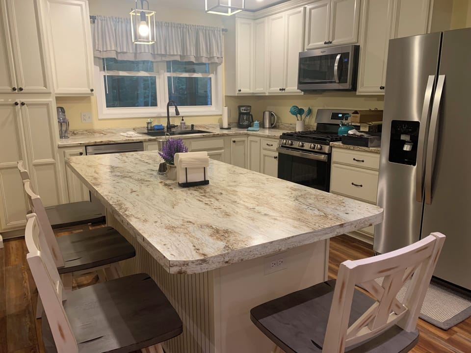 Kitchen island seating up to six persons. Extra barstools in the living room.