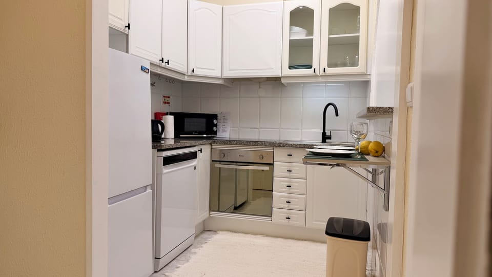 Cozinha completa totalmente equipada e com pequena mesa de apoio para dois