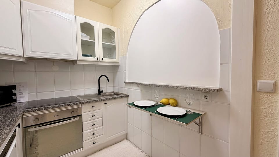 Cozinha completa totalmente equipada e com pequena mesa de apoio para dois