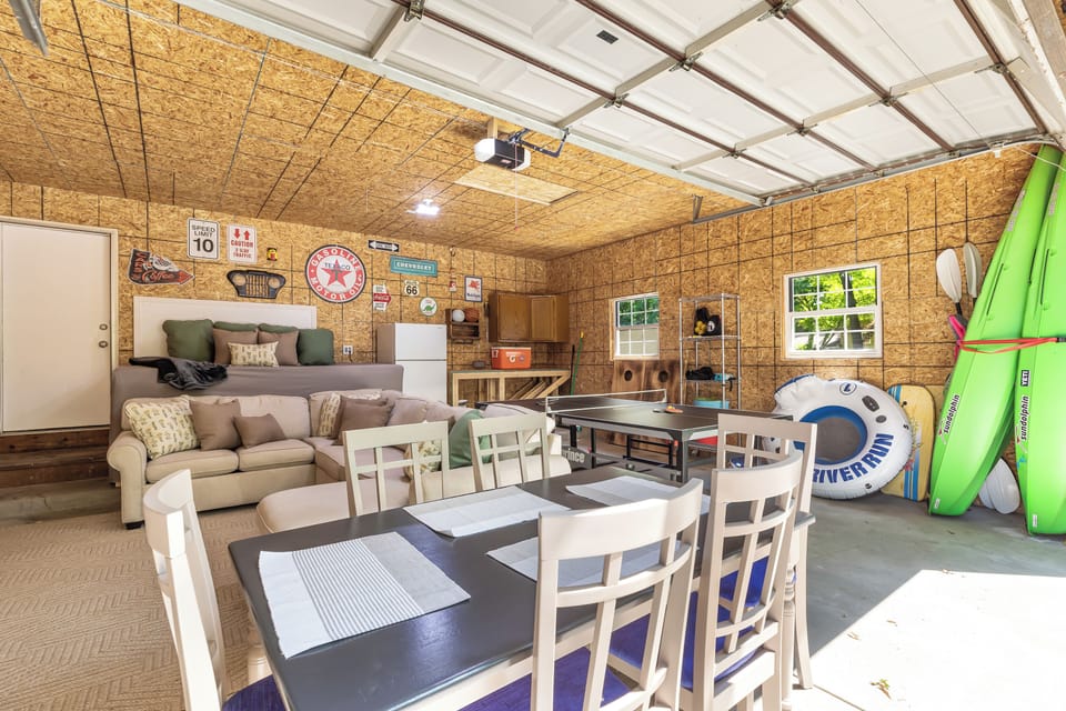 This spacious garage has been converted into a charming dining area with a rustic dining table and comfortable chairs. The perfect place to enjoy a meal with family and friends.