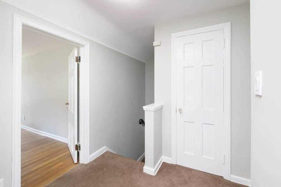 - Neutral hallway with fresh paint and soft carpet flooring   - Easy access to bedrooms and main living areas upstairs   - Bright doorway with natural light enhances open feel  