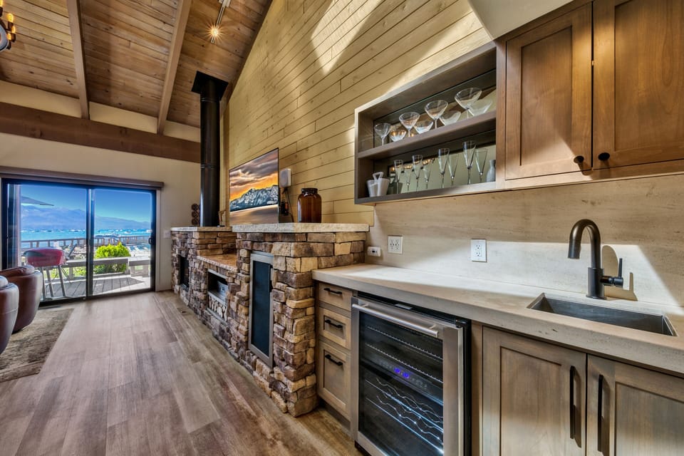 Your rustic-chic kitchen beckons with warm wood tones and stone fireplace, while mountain vistas frame your culinary adventures.