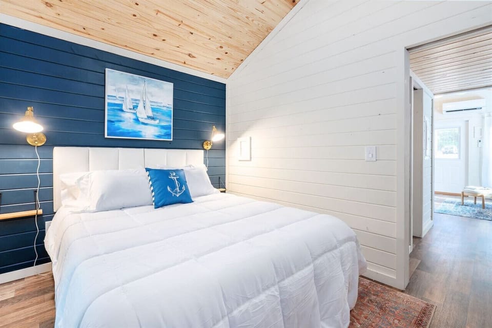 Serene Retreat: Nestle into this queen bed with nautical decor and natural light for perfect relaxation!