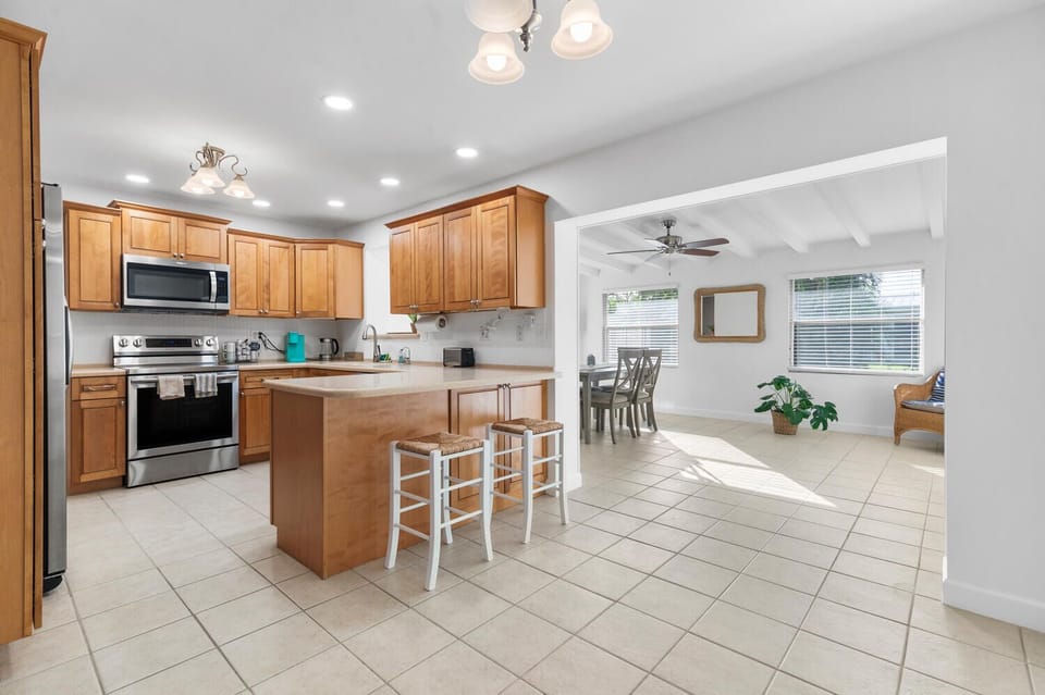 Welcome to the heart of the home! This bright and airy kitchen features stainless steel appliances and bar seating. Adjacent to the kitchen, the spacious dining room boasts a table for six, enhanced by a large sliding door that invites natural light.