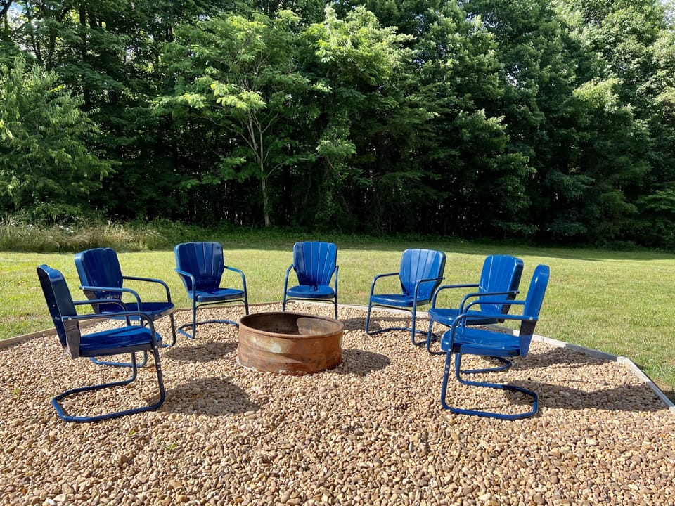 Back fire pit with views of the backyard and nearby hot tub