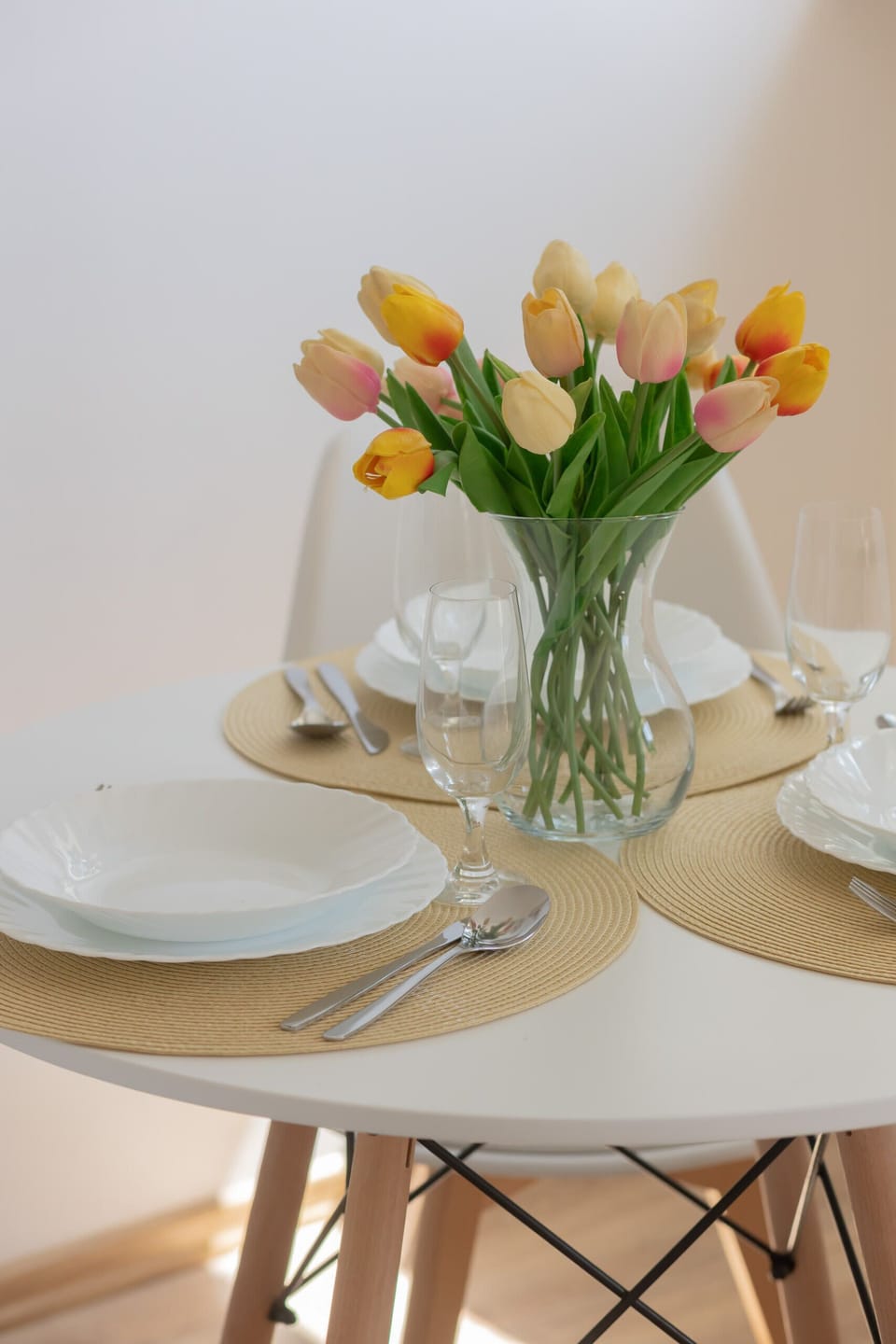 A close-up of a table setting with yellow tulips adding vibrancy to the space.

